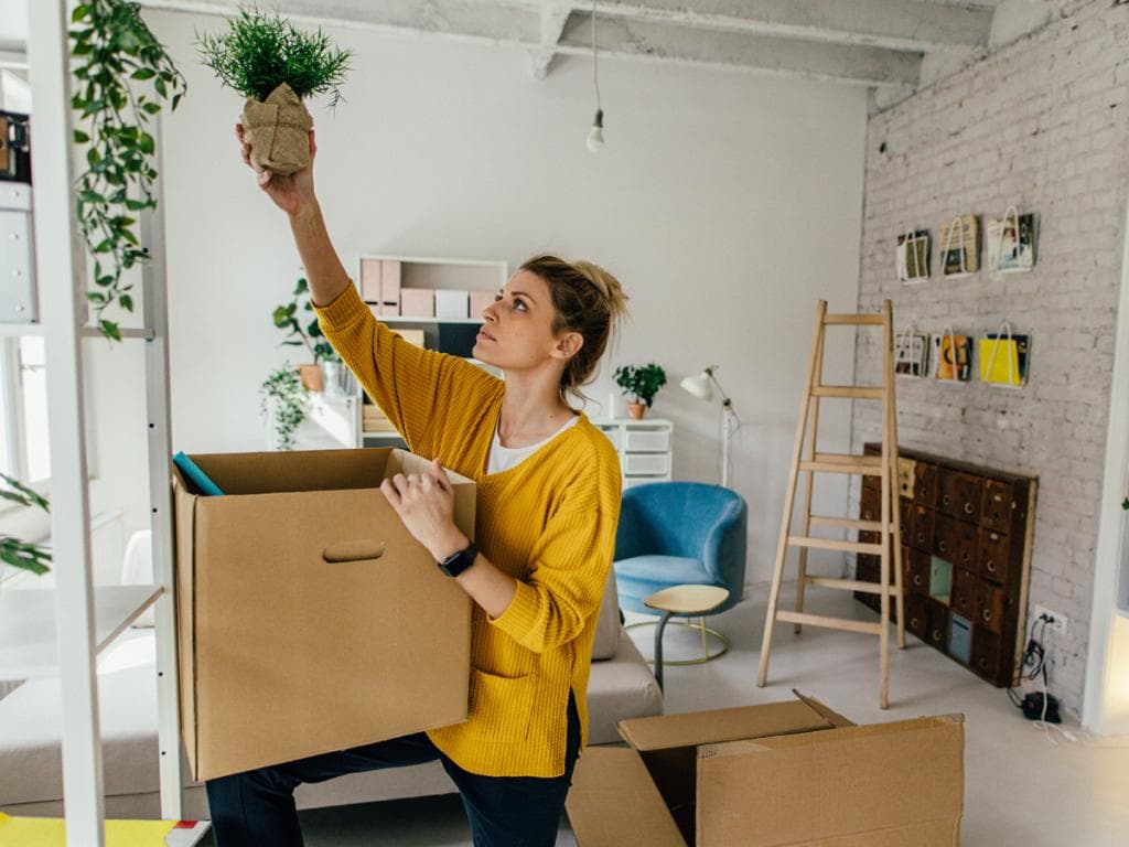 Un bărbat zâmbitor stă la o masă, înconjurat de alte persoane, bucurându-se de o adunare socială